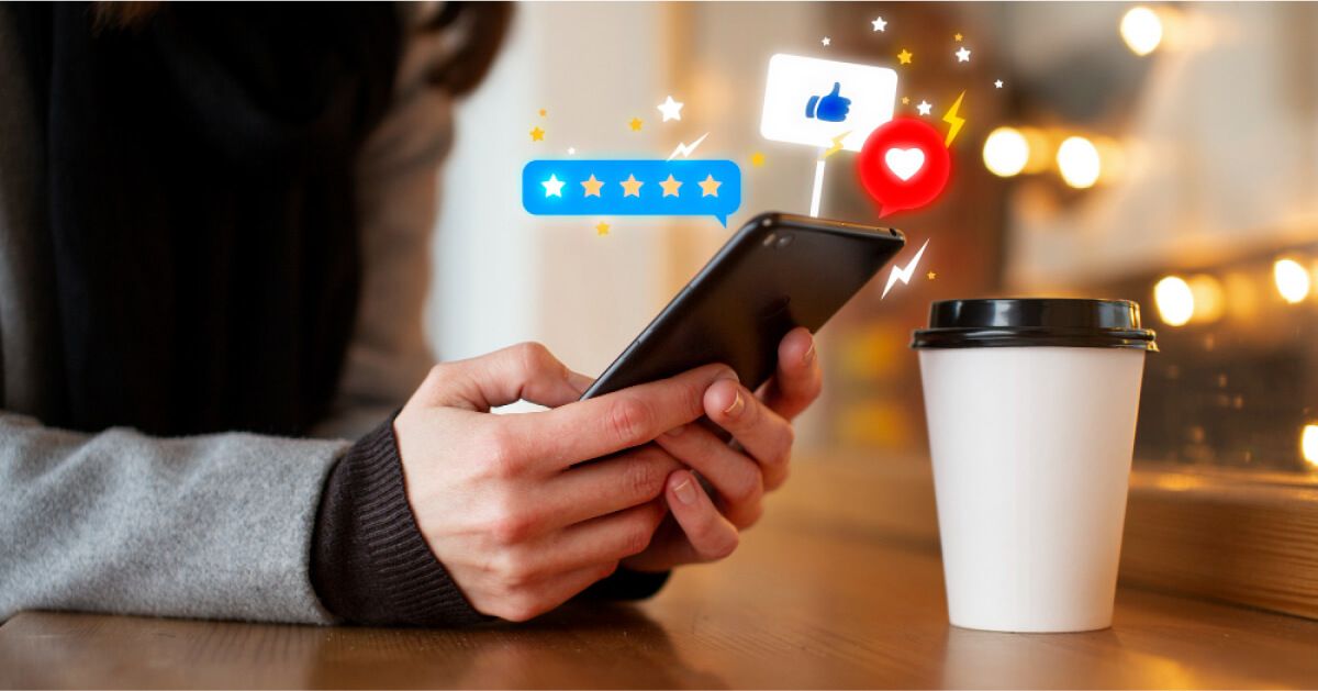 Person using a smartphone, with graphics of reactions & reviews