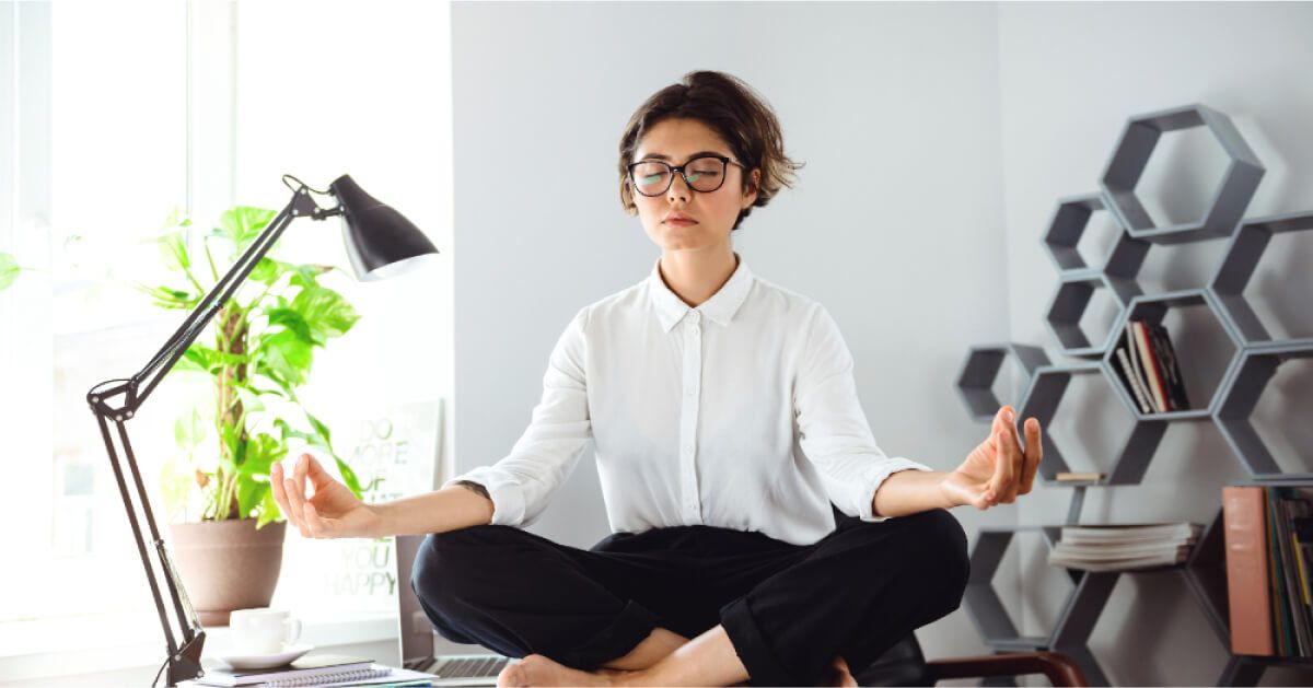 Woman in a meditative pose in an office setting